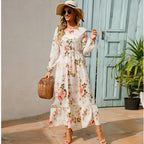 Cream floral maxi dress with long sleeves, gathered waist, and tiered skirt