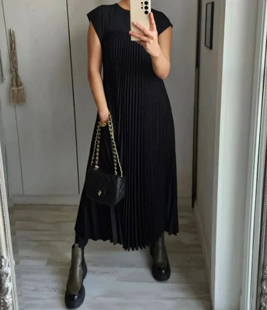 Black pleated maxi dress with cap sleeves and back-to-front flow