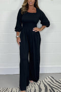 Black square-neck jumpsuit set with elbow puff sleeves and wide-leg pants.
