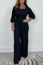 Black square-neck jumpsuit set with elbow puff sleeves and wide-leg pants.