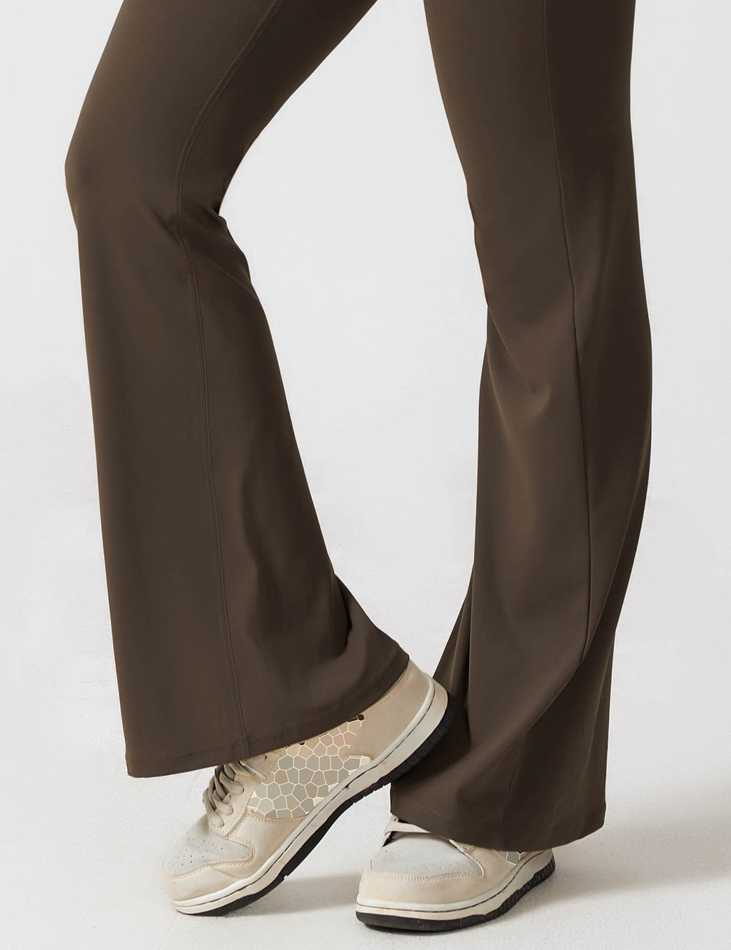 Black flared-leg jumpsuit with split-style bottom and low-profile sneakers