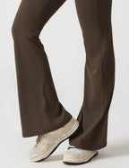 Black flared-leg jumpsuit with split-style bottom and low-profile sneakers