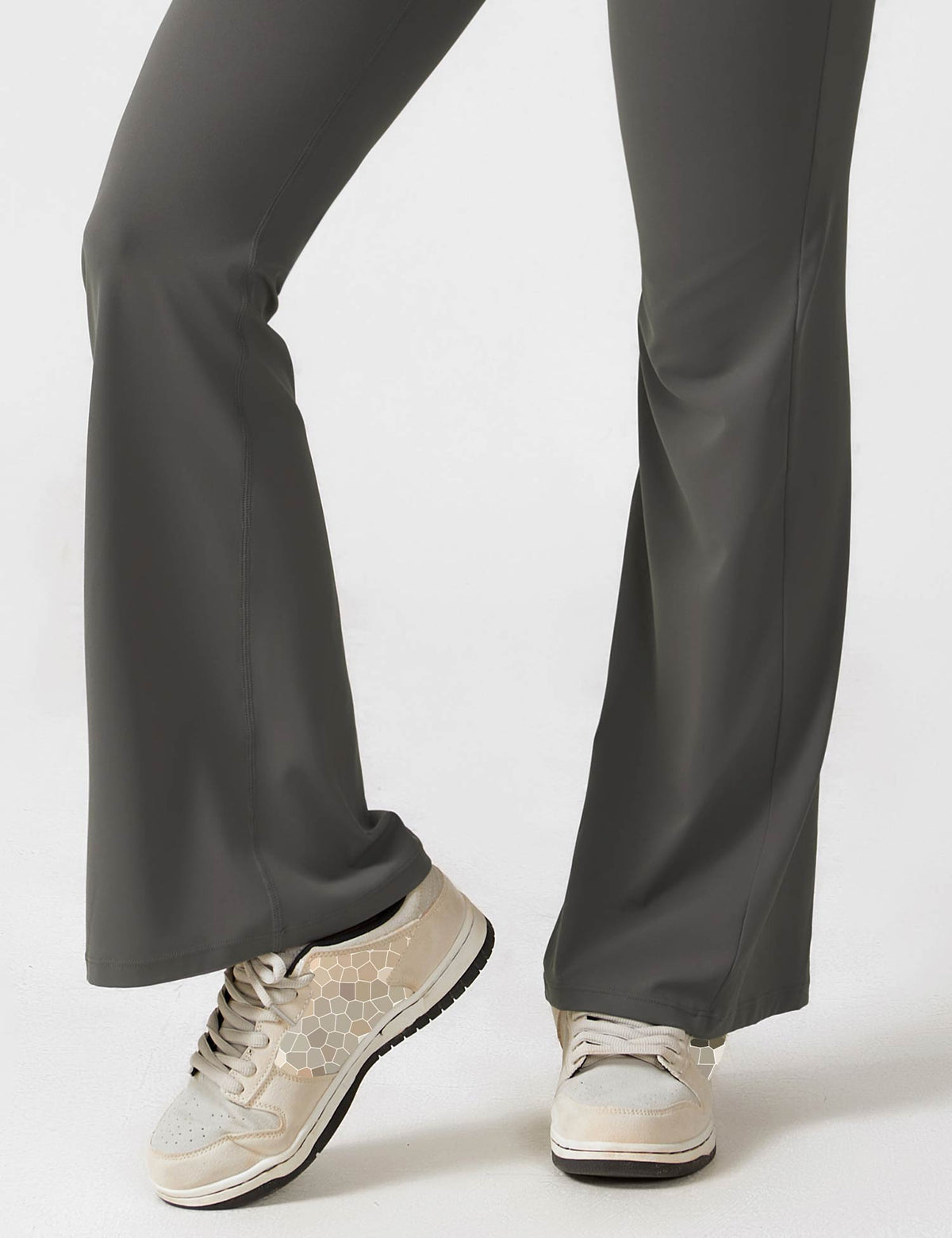 Wide-leg maroon jumpsuit pants with flared hems and sneakers at the cuff.