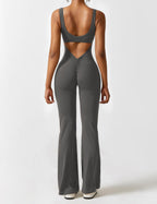 Athletic jumpsuit in dark gray with open back and flared pant legs.