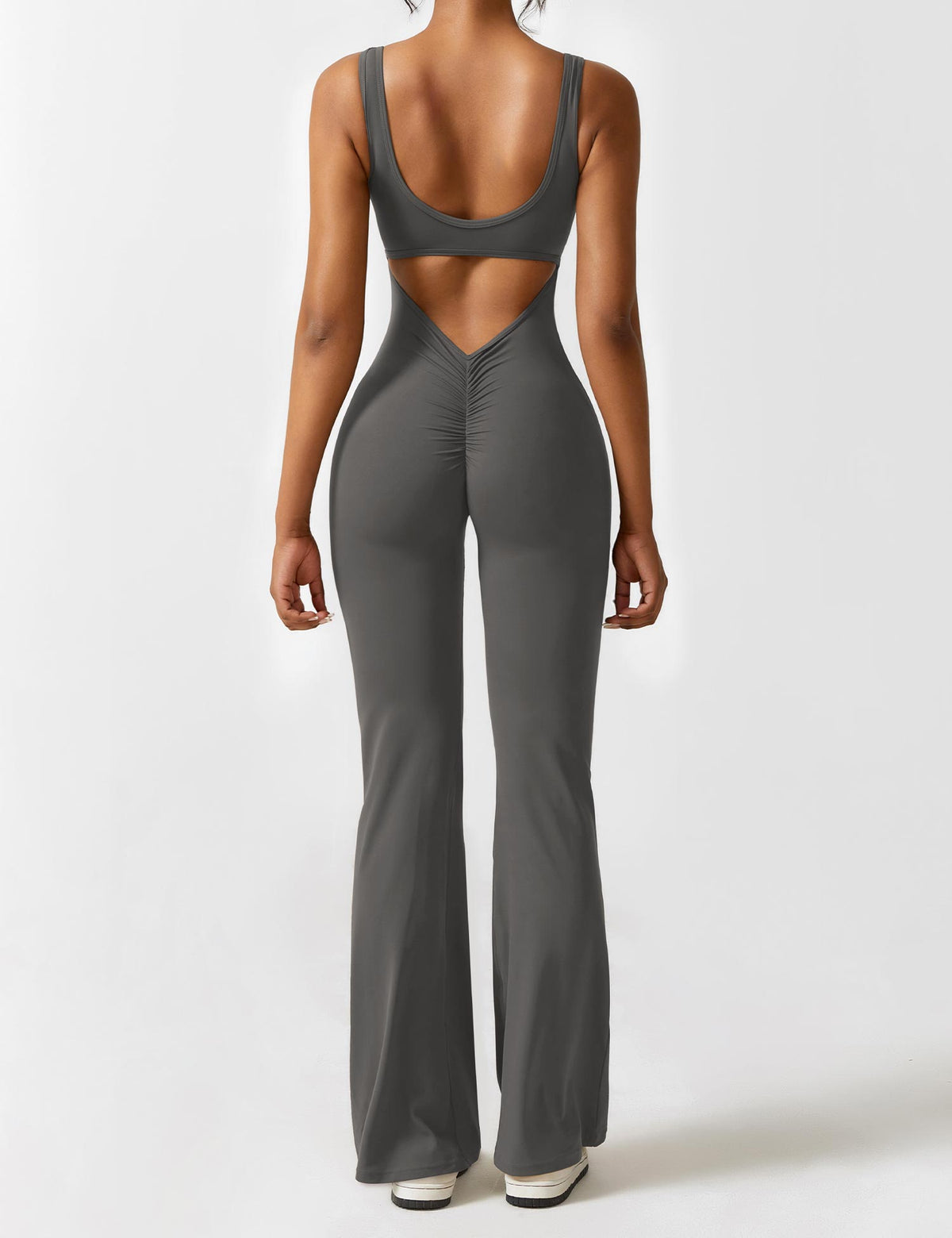 Athletic jumpsuit in dark gray with open back and flared pant legs.
